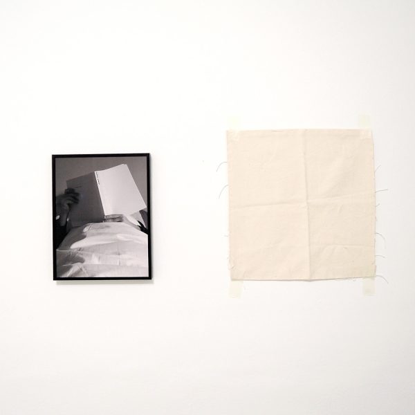 Misha Bies Golas. Leyendo sobre y tras él, 2015. Monocromo blanco. Díptico: fotografía blanco y negro y lona. Edición: 2 + 1